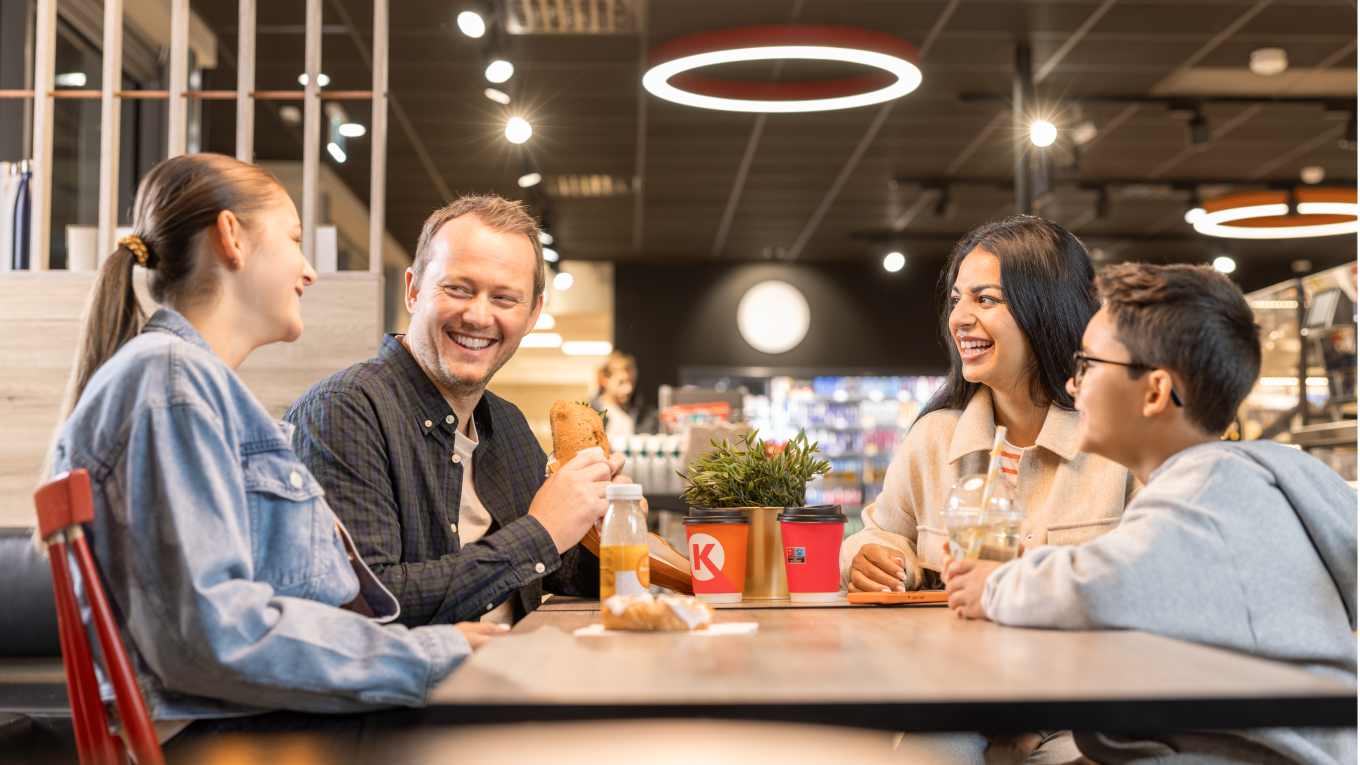 Gezin dat gezellig aan tafel zit te lachen in een Circle K store