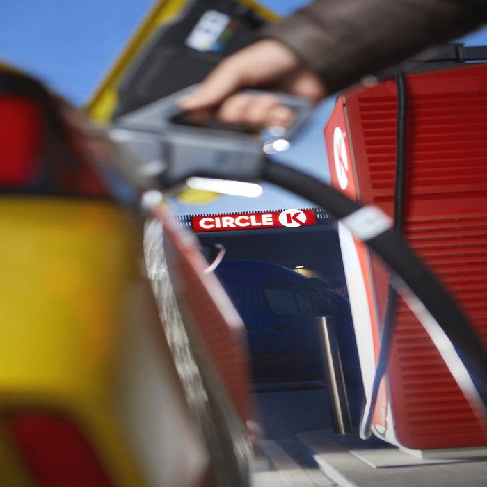Auto wordt opgeladen, met op de achtergrond duidelijk het Circle K-logo zichtbaar