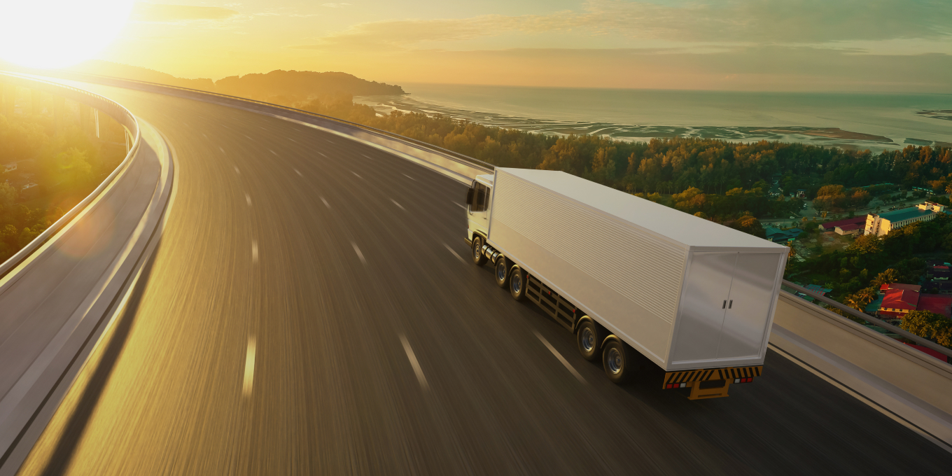 Rijdende vrachtwagen op snelweg tijdens zonsondergang